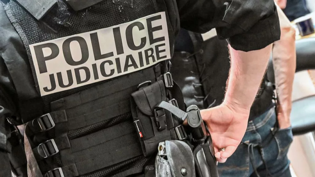 A police officer wearing a bulletproof vest reads "judicial police" stands at the International Cybersecurity Forum (FIC) in Lille, northern France, on September 7, 2021.