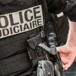 A police officer wearing a bulletproof vest reads "judicial police" stands at the International Cybersecurity Forum (FIC) in Lille, northern France, on September 7, 2021.