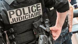 A police officer wearing a bulletproof vest reads "judicial police" stands at the International Cybersecurity Forum (FIC) in Lille, northern France, on September 7, 2021.